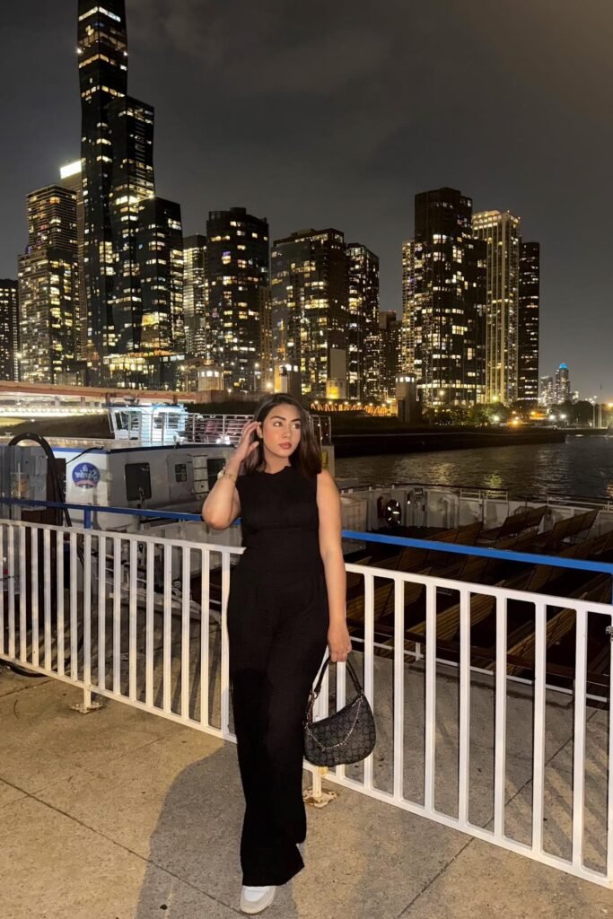 Black Sleeveless Jumpsuit + Black Patterned Shoulder Bag + White Sneakers