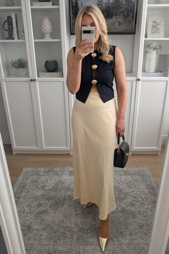 Black Sleeveless Vest with Gold Shell Buttons + Cream Satin Maxi Skirt + Gold Pointed Heels