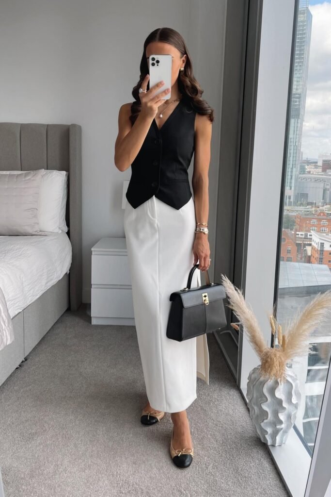 Black Tailored Vest + White Column Maxi Skirt + Black Leather Top Handle Bag + Two Tone Cap Toe Flats