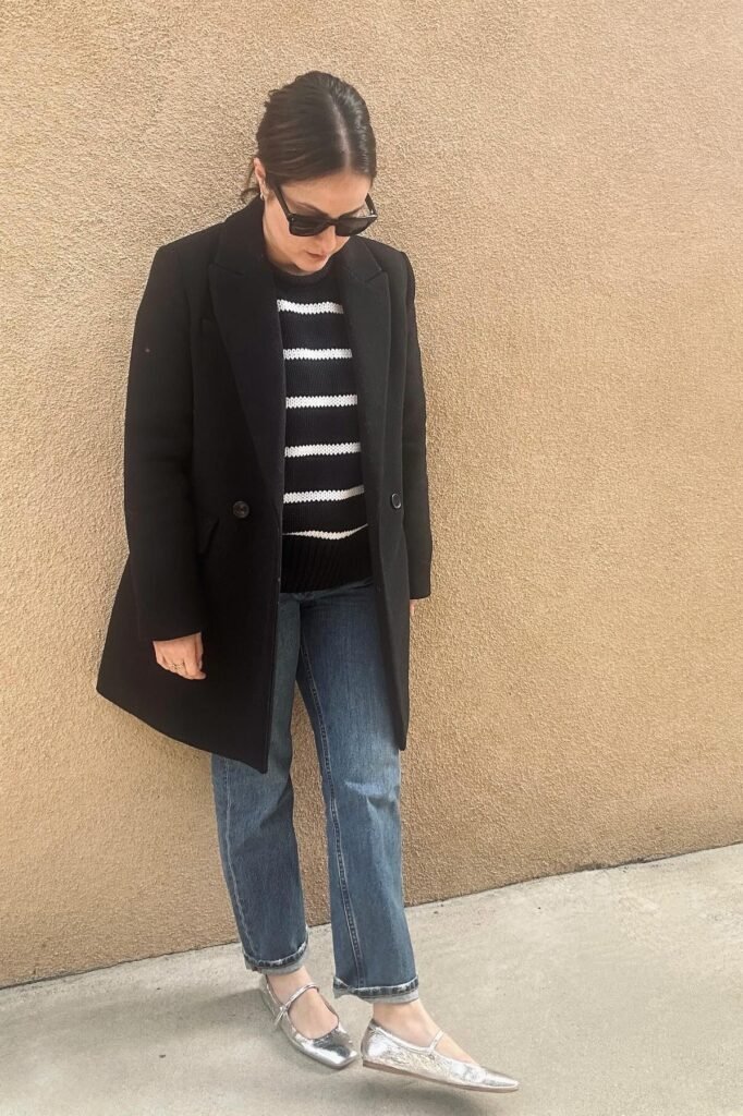 Black & White Striped Sweater + Black Overcoat + Straight Leg Blue Jeans + Silver Mary Jane Flats