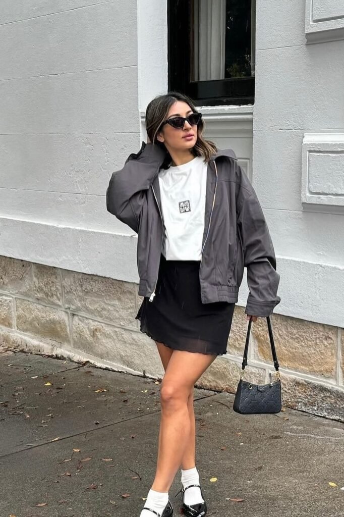 Charcoal Bomber Jacket + White Graphic T Shirt + Black Mini Skirt + White Socks + Black Mary Jane Flats