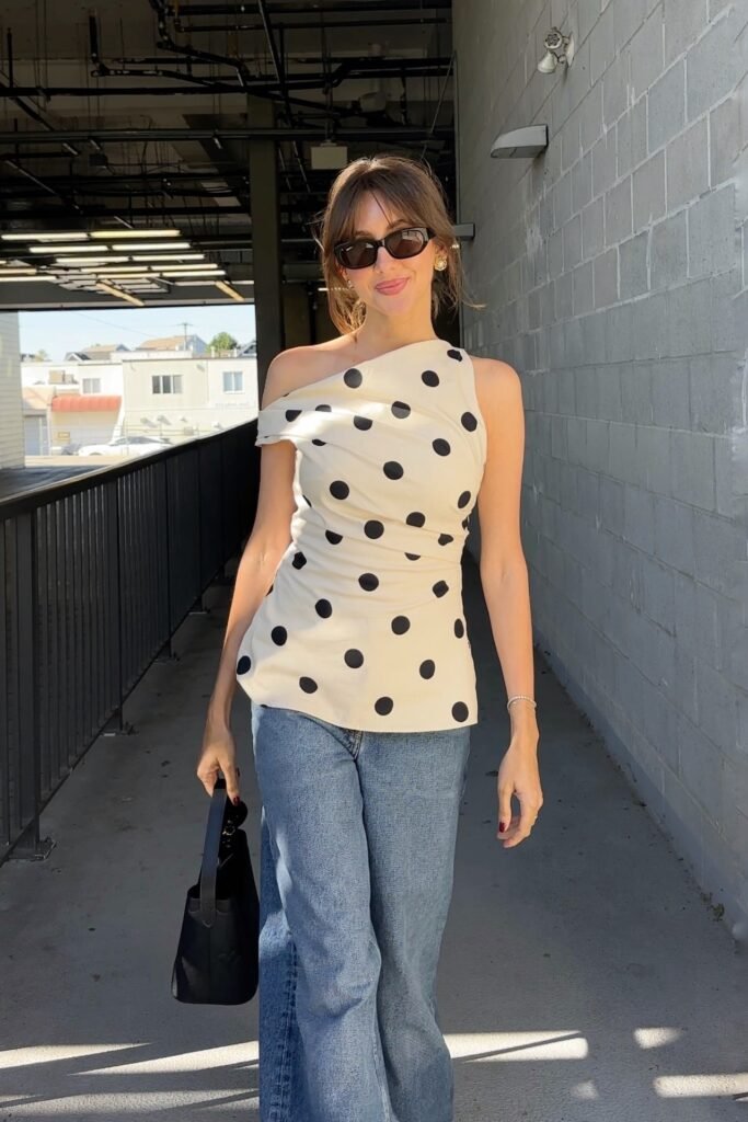 Cream Polka Dot One-Shoulder Drape Top + Blue Wide-Leg Jeans + Black Sunglasses