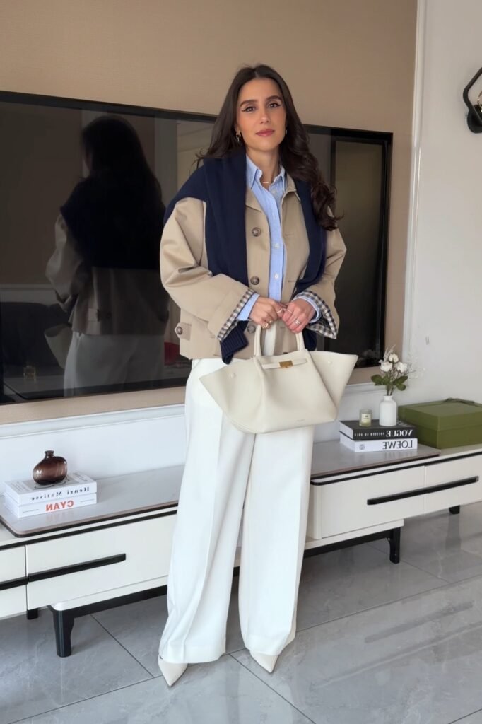 Cropped Khaki Trench Coat + Blue Button-Down + White Wide-Leg Trousers + Cream Winged Tote
