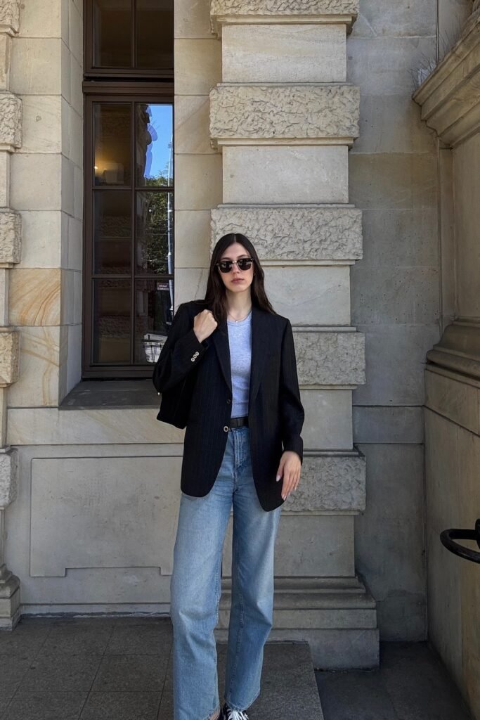 Light Grey T Shirt + Black Pinstripe Blazer + Medium Wash Straight Leg Jeans + Black and White Sneakers