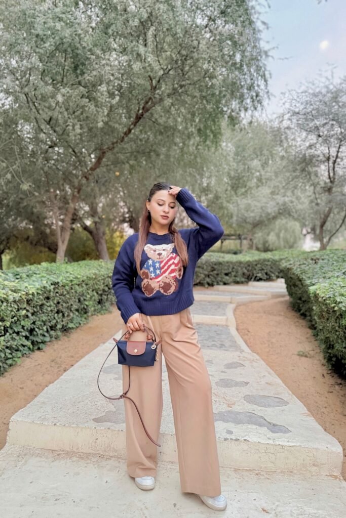 Navy Bear Graphic Sweater + Tan Wide-Leg Trousers + White Platform Sneakers + Navy Mini Handbag