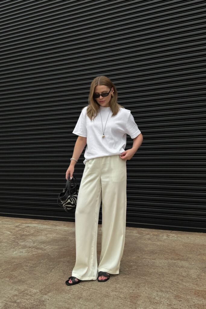 Oversized White T Shirt + Cream Satin Wide Leg Trousers + Black Slide Sandals