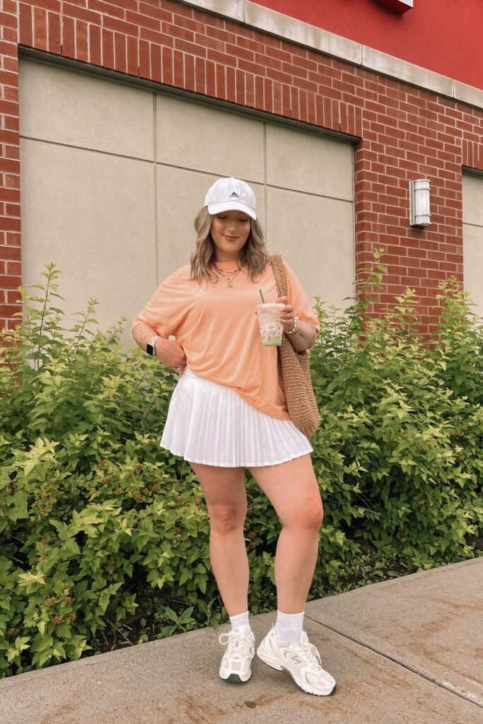 Peach Oversized T-shirt + White Pleated Tennis Skirt + White Athletic Sneakers