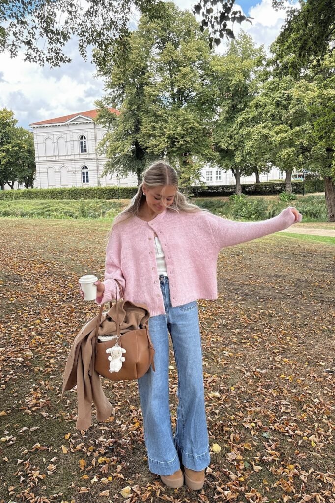 Pink Knit Cardigan + White Corset Top + Light Wash Wide Leg Jeans + Tan Platform Ugg Style Boots