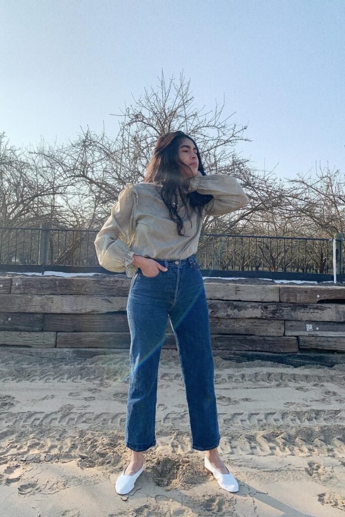 Pinstripe Ruffle Blouse + High-Waisted Blue Jeans + White Pointed-Toe Flats