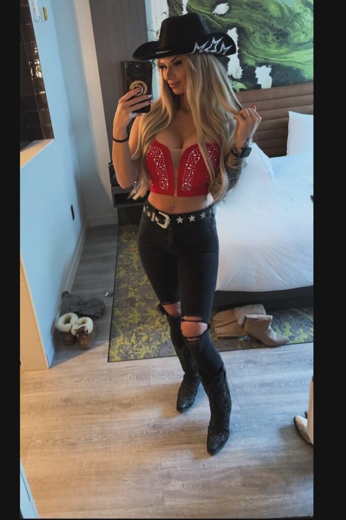 Red Embellished Corset Top + Black Ripped Skinny Jeans + Black Western Boots + Black Cowboy Hat with Silver Details
