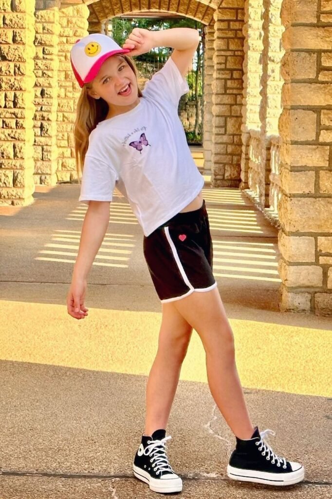 White Butterfly Graphic T-shirt + Black Athletic Shorts + Pink Trucker Hat + Black High-Top Sneakers