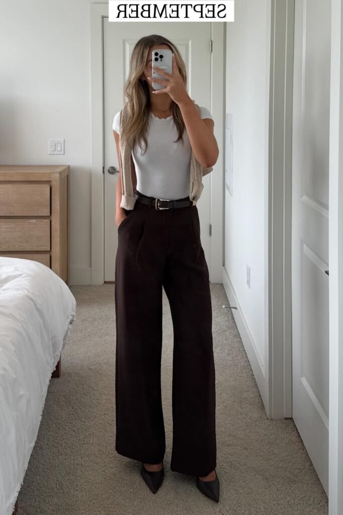 White Crew-Neck T-Shirt + Beige Sweater Over Shoulders + Dark Brown High-Waisted Trousers + Black Pointed-Toe Heels