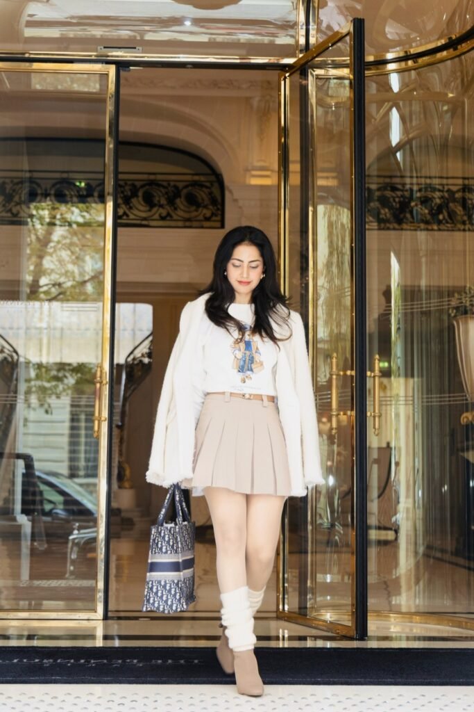 White Graphic Sweater + Beige Pleated Mini Skirt + Cream Leg Warmers + Tan Pointed Boots