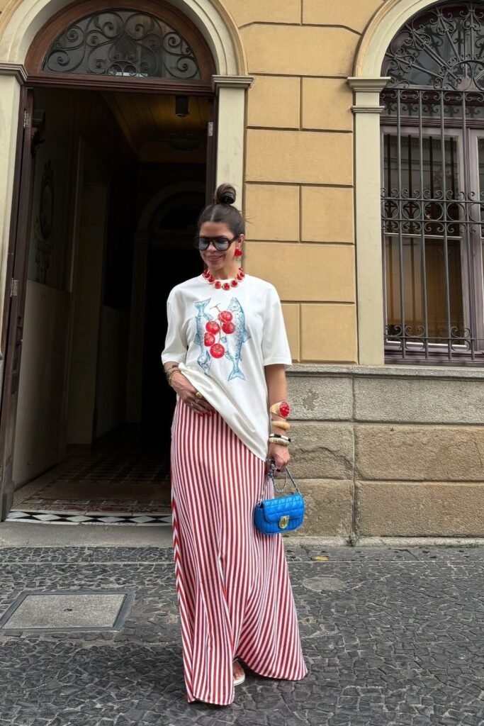 White Graphic T-Shirt + Red and White Vertical Striped Maxi Skirt + Blue Quilted Handbag