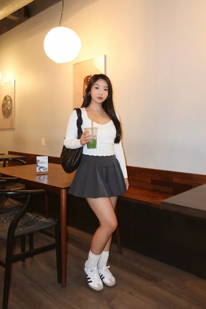 White Long-Sleeve Ribbed Top + Dark Grey Pleated Mini Skirt + White Sneakers with Black Stripes