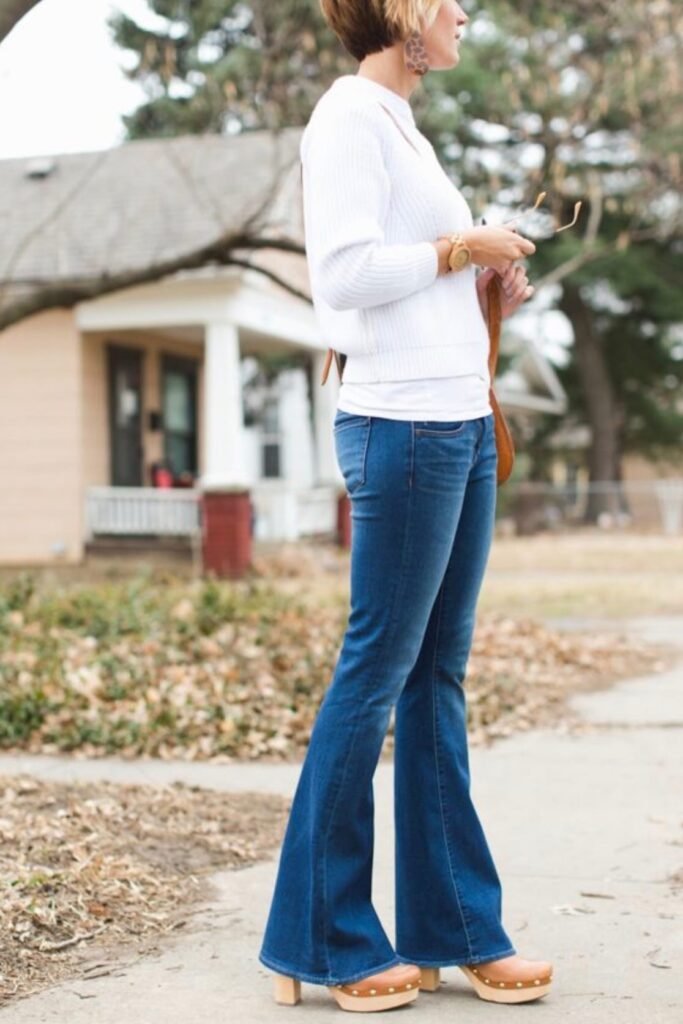 White Ribbed Sweater + Blue Bell-Bottom Jeans + Tan Platform Clogs