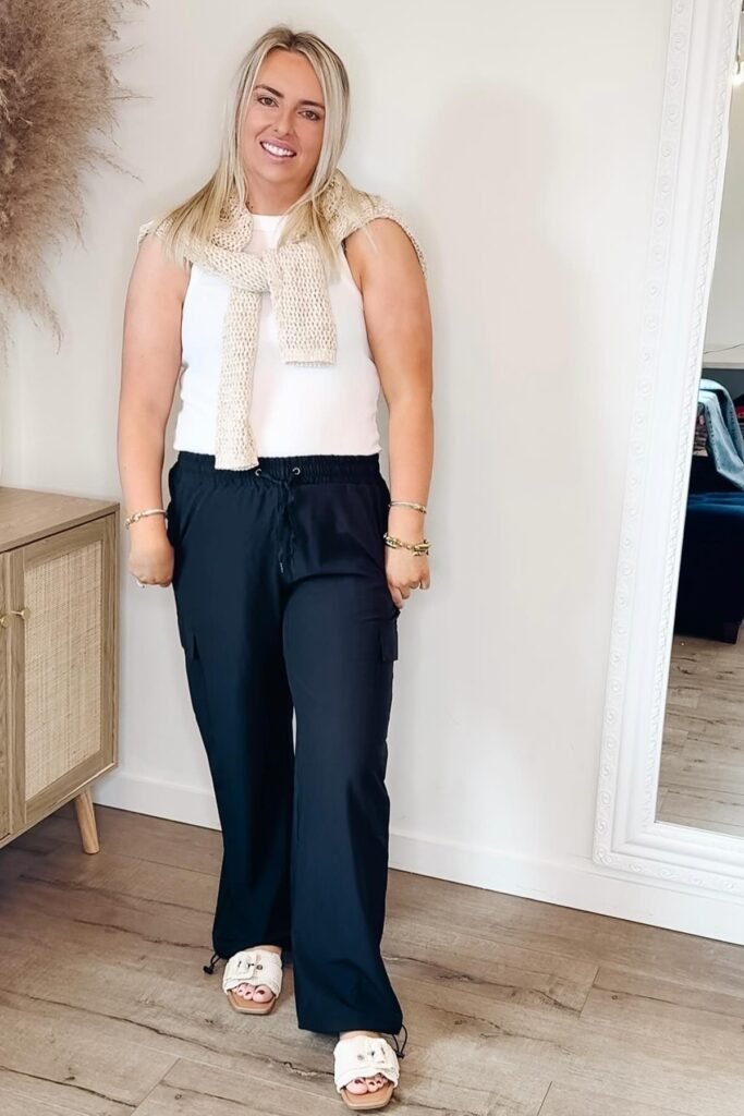White Ribbed Tank Top + Cream Knit Sweater (over shoulders) + Navy Cargo Trousers + White Buckle Slides