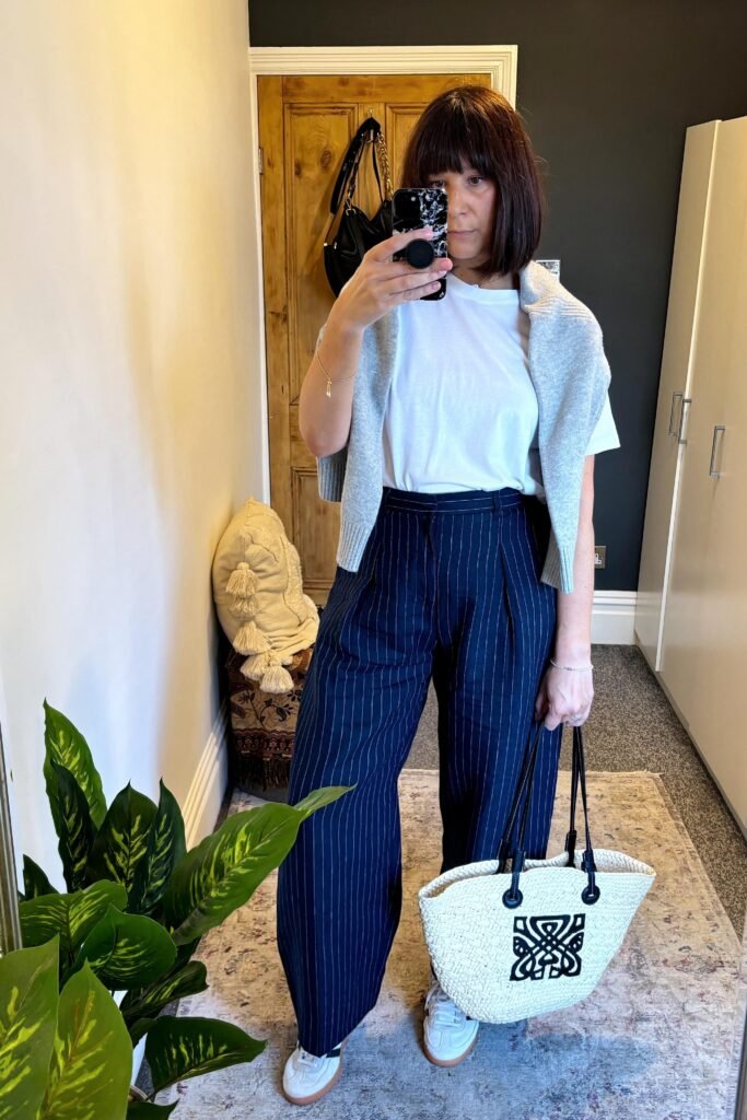 White T Shirt + Light Grey Sweater (Shoulder Drape) + Navy Pinstripe Wide Leg Trousers + White Sneakers