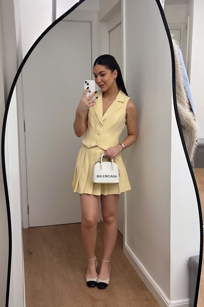 Yellow Sleeveless Waistcoat + Yellow Pleated Mini Skirt + Two-Tone Cap-Toe Heels