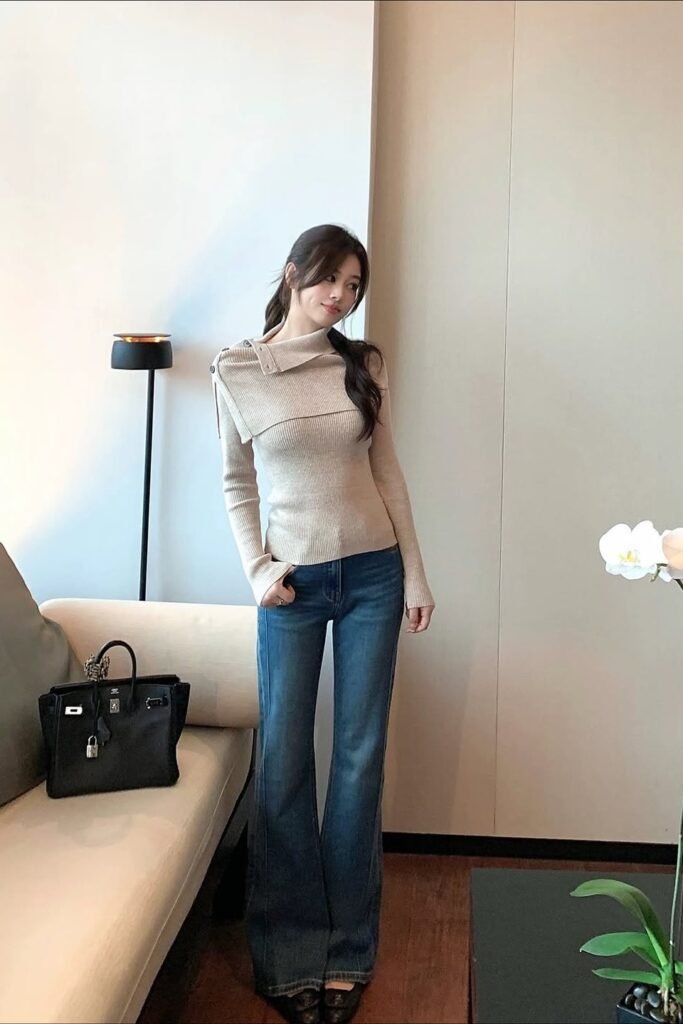 Beige Asymmetrical Fold-Over Sweater + Medium Wash Flared Jeans + Black Cap-Toe Flats