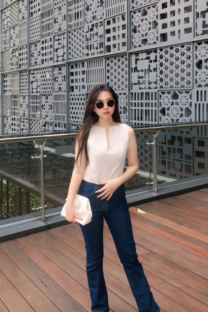 Beige Sleeveless Split-Neck Top + Dark Wash Flare Jeans + Round Sunglasses