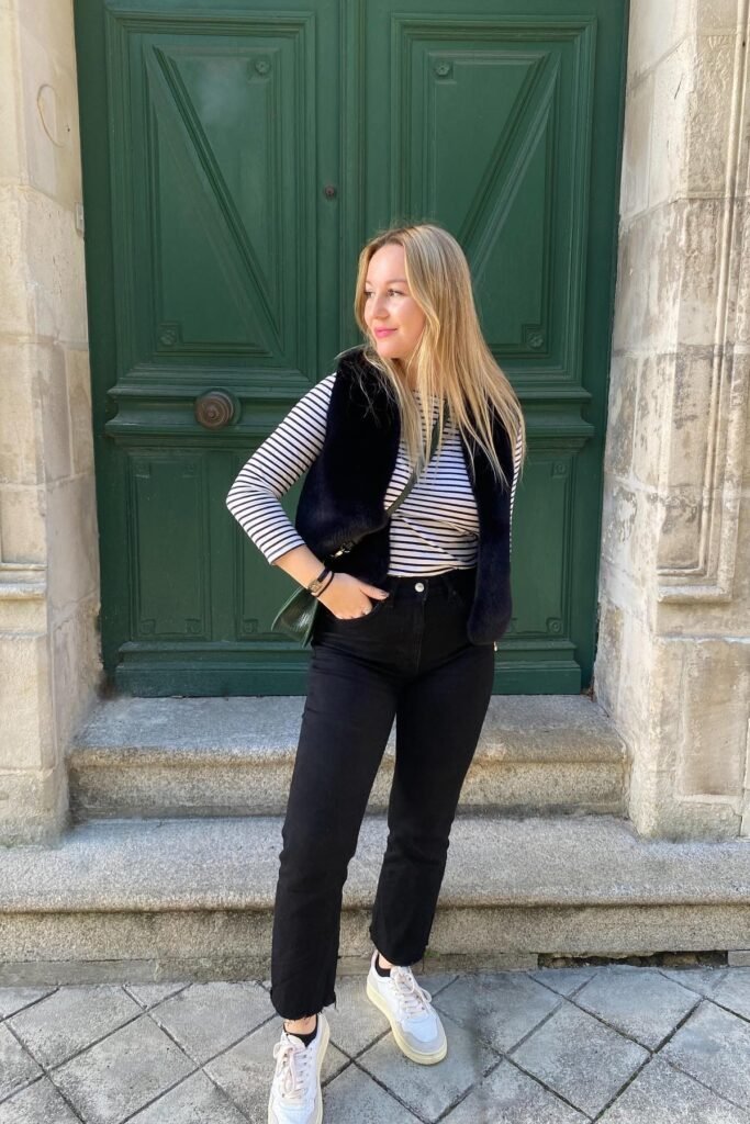 Black Faux Fur Vest + Striped Long-Sleeve Top + Black Straight-Leg Jeans + White Sneakers