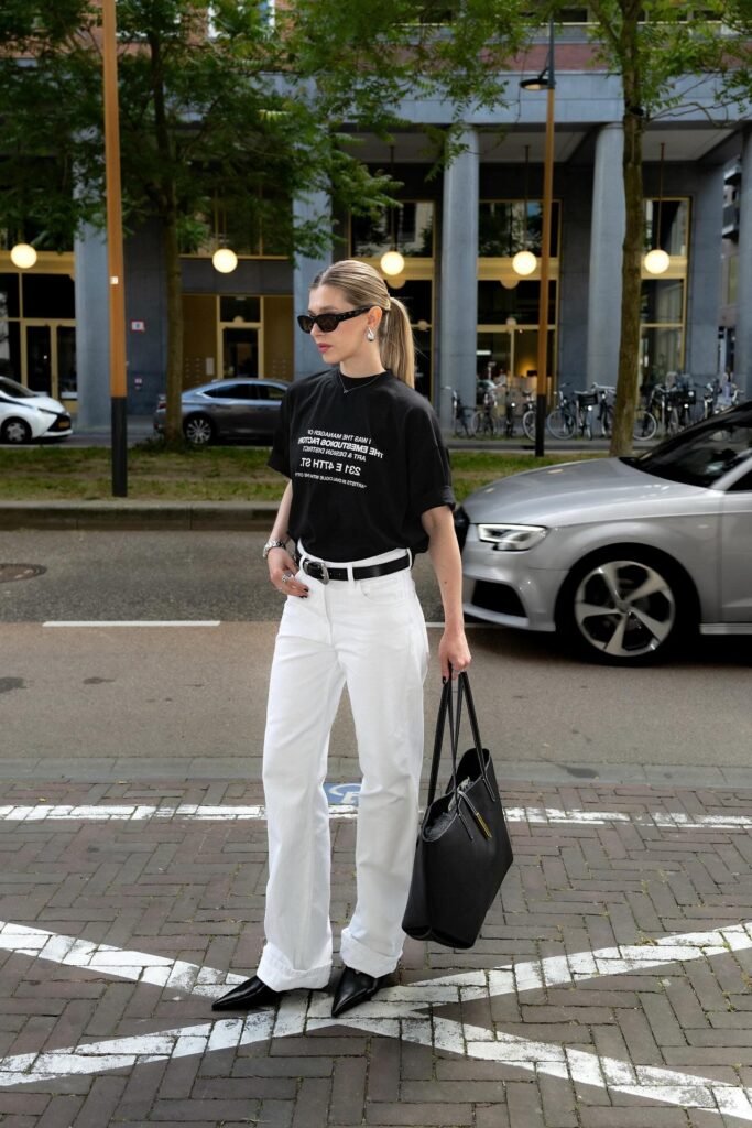 Black Graphic T-Shirt + White Wide-Leg Cuffed Jeans + Black Pointed-Toe Boots