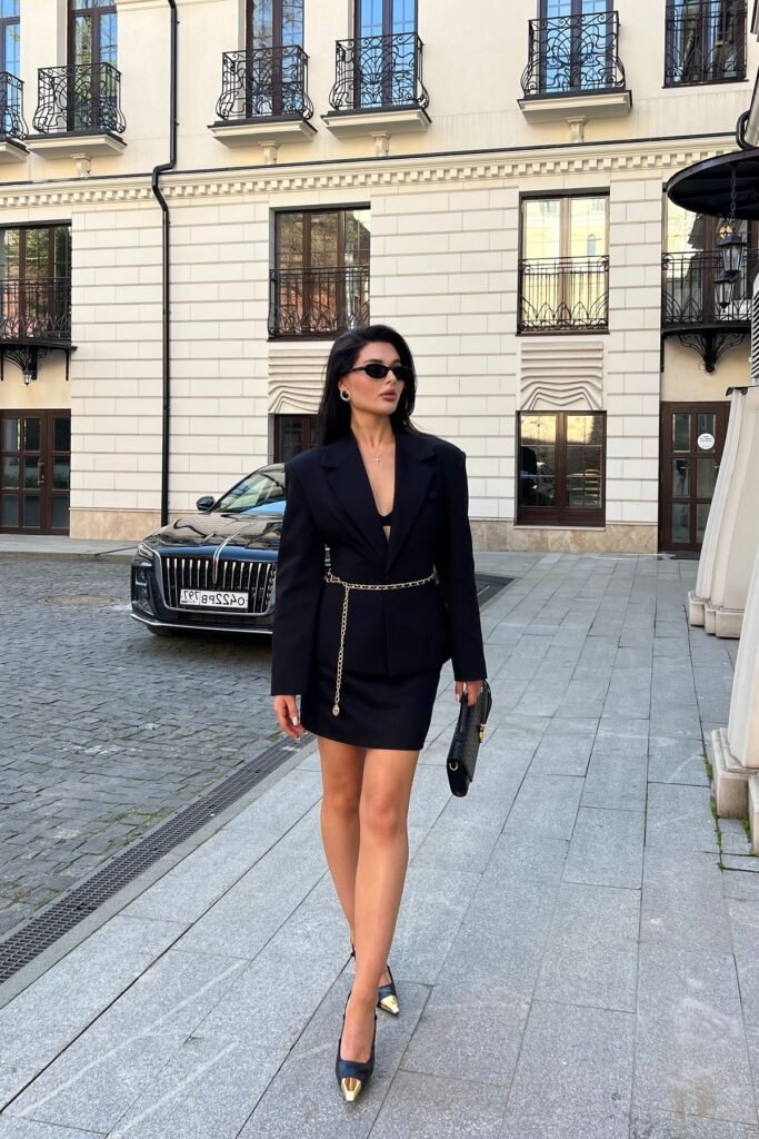 Black Oversized Blazer + Black Mini Skirt + Gold Chain Belt + Black Gold-Toed Pumps