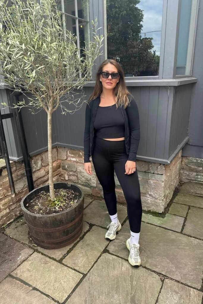 Black Zip-Up Jacket + Black Crop Top + Black Leggings + Chunky White Sneakers