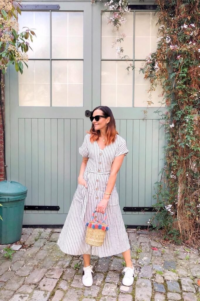 Black and White Vertical Striped Button-Front Dress + White Sneakers + Colorful Pom-Pom Straw Bag