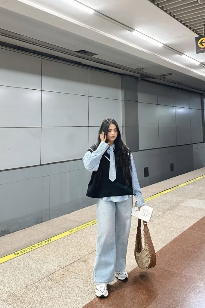 Blue Striped Button-Down + Black Knit Vest + Light Wash Wide-Leg Jeans + White Chunky Sneakers