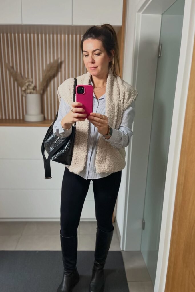 Cream Sherpa Vest + Striped Button-Down Shirt + Black Leggings + Black Knee-High Boots