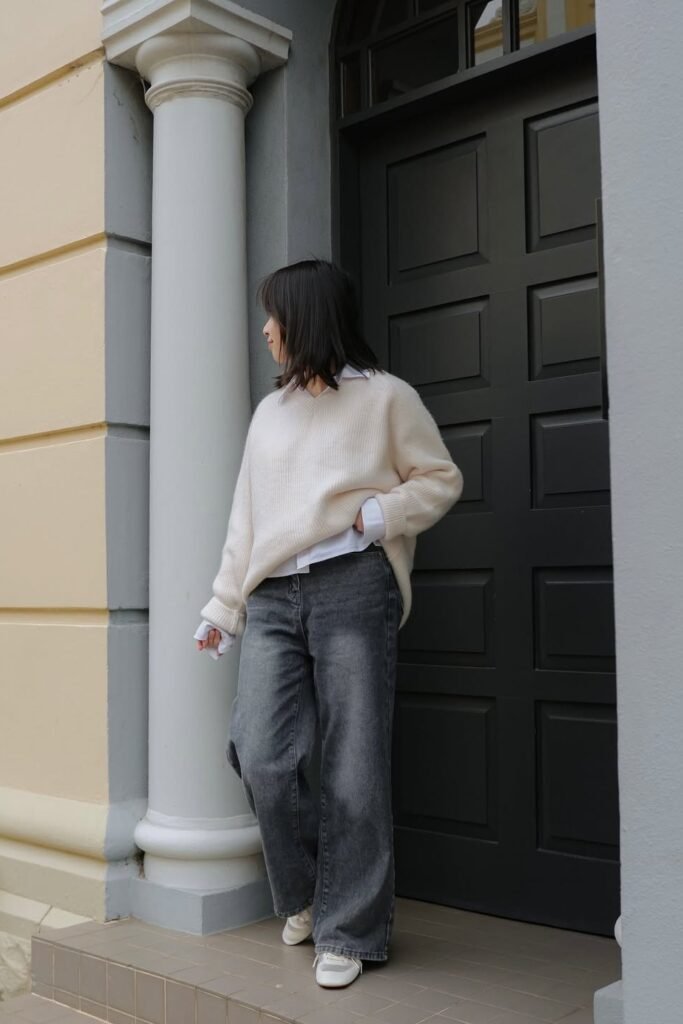 Cream V-Neck Sweater over White Button-Down Shirt + Charcoal Grey Wide-Leg Jeans + White Sneakers