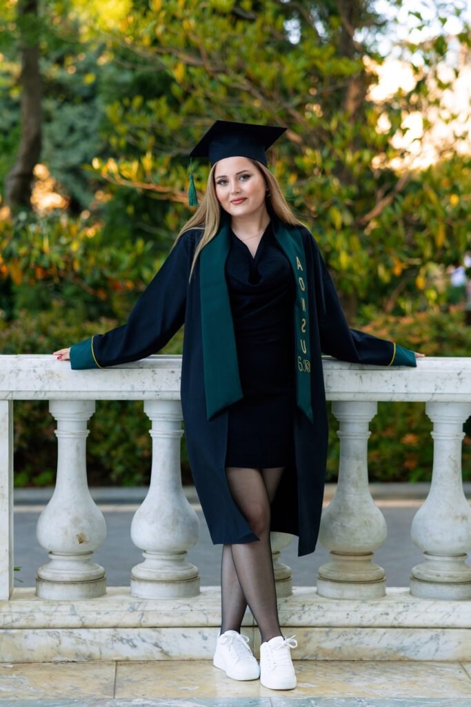 Dark Graduation Gown and Cap + Black Mini Dress + Black Sheer Tights + White Sneakers