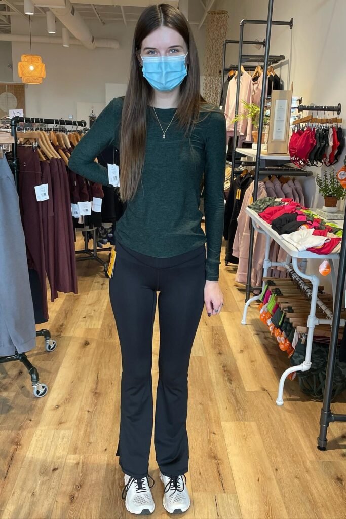 Dark Green Long-Sleeved Top + Black Flared Yoga Pants + White & Black Athletic Sneakers