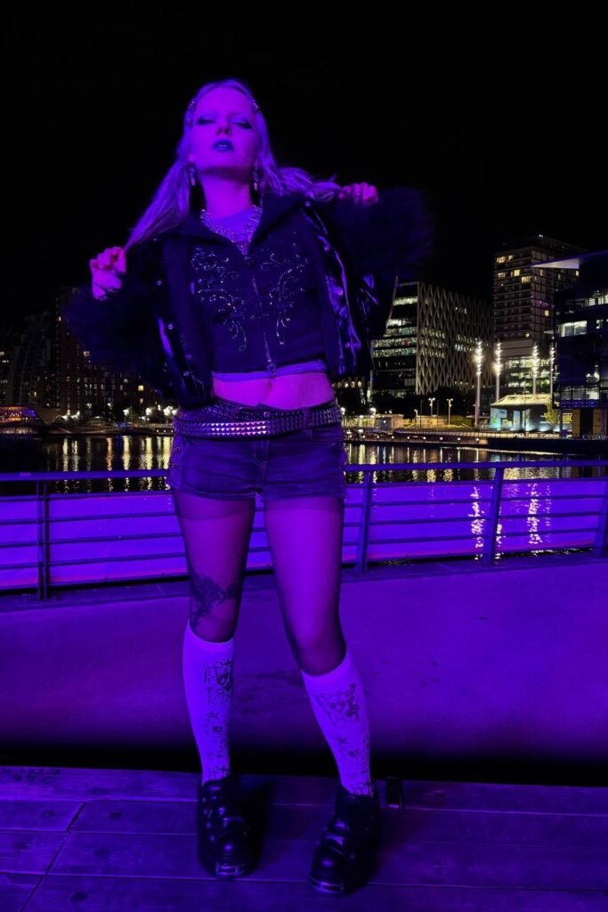 Embellished Black Zip-up Jacket + Denim Micro-shorts + Graphic Knee-high Socks