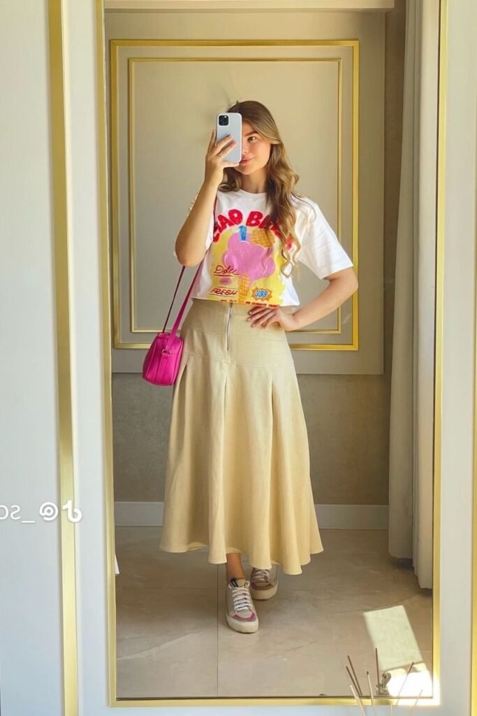 Graphic Print Crop T-Shirt + Beige Pleated Midi Skirt + Pink Crossbody Bag + White Sneakers