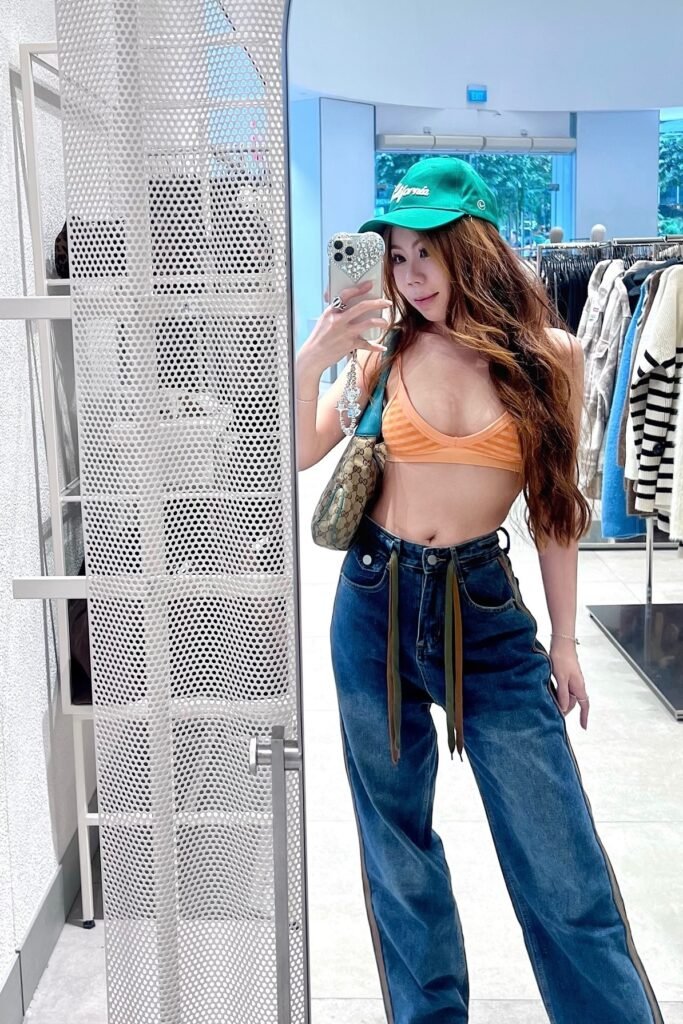 Green Baseball Cap + Orange Striped Bralette + Wide Leg Indigo Jeans + Designer Shoulder Bag