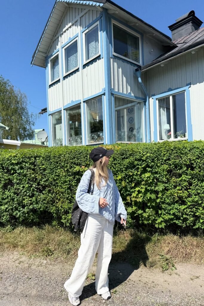 Light Blue Cable Knit Sweater + White Wide-Leg Linen Pants + Black Baseball Cap + White Sneakers