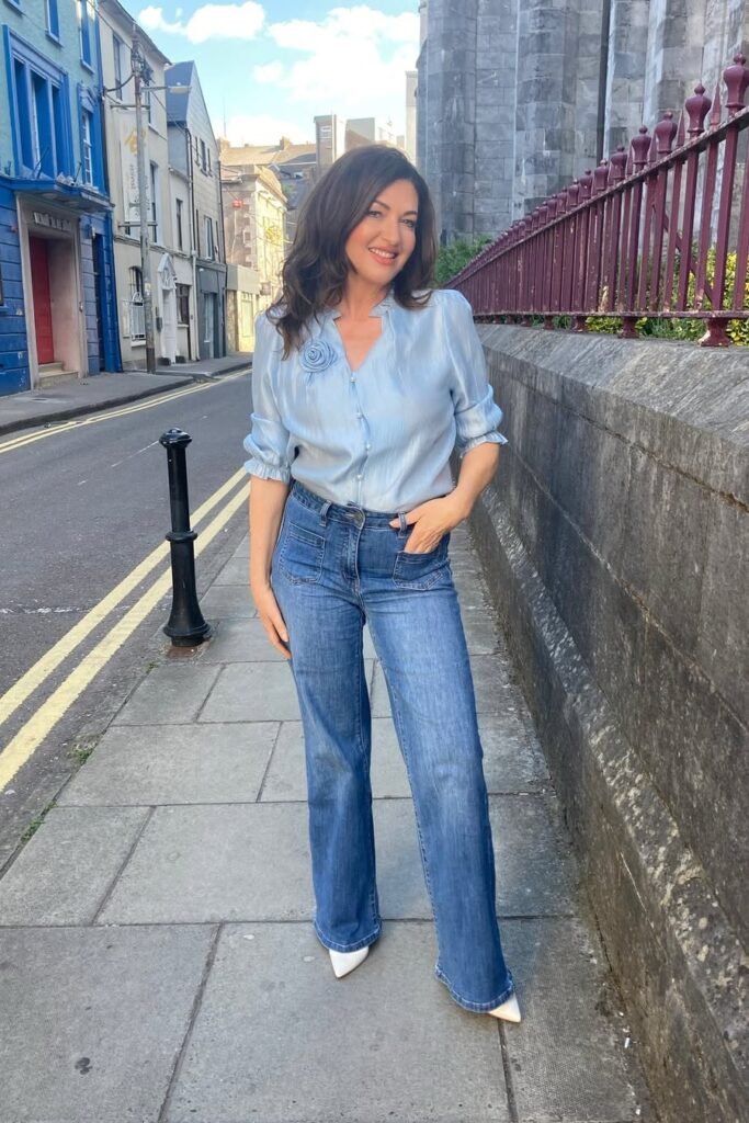 Light Blue Ruffled Blouse with Flower Detail + Straight-Leg Blue Jeans + White Pointed Heels