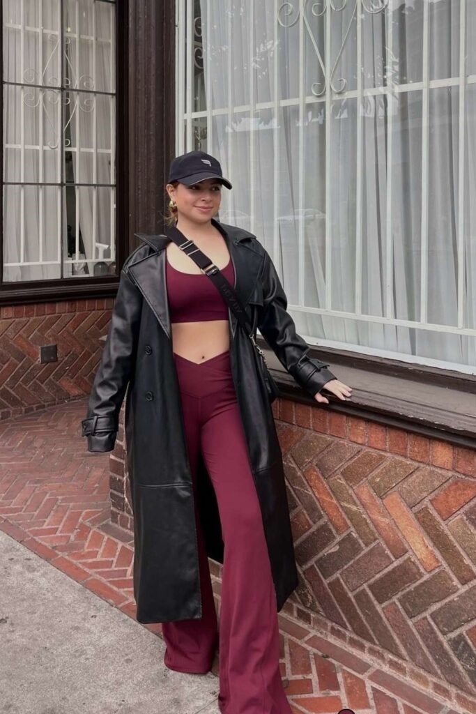 Long Black Leather Coat + Burgundy Crop Top & Flared Trousers + Black Cap