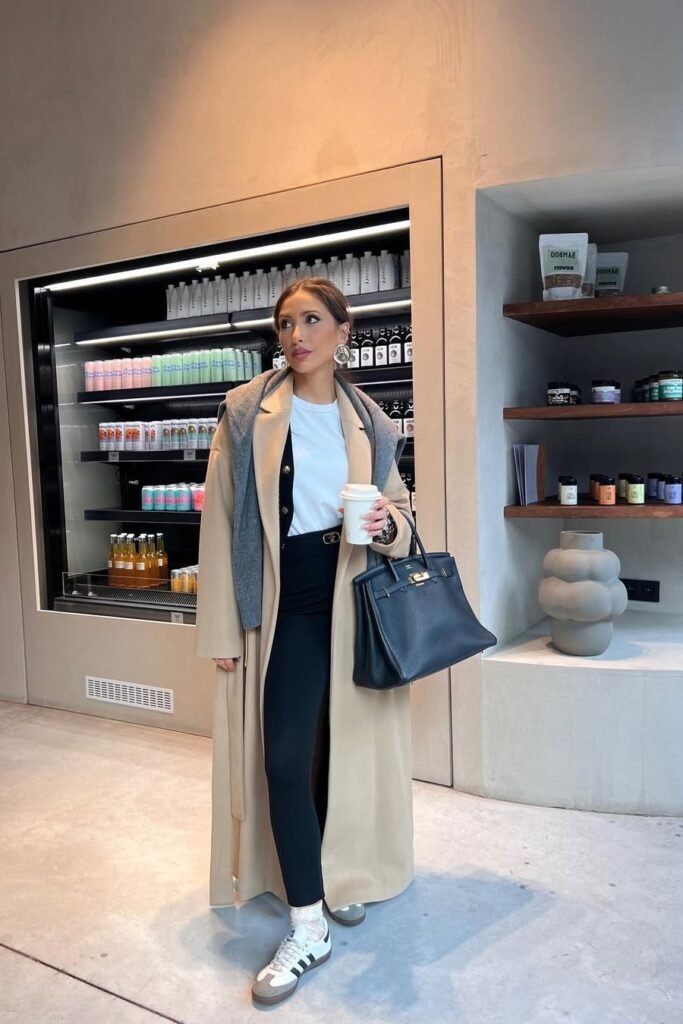 Long Camel Coat + White T-Shirt + Black Leggings + White Sneakers + Grey Shoulder Sweater