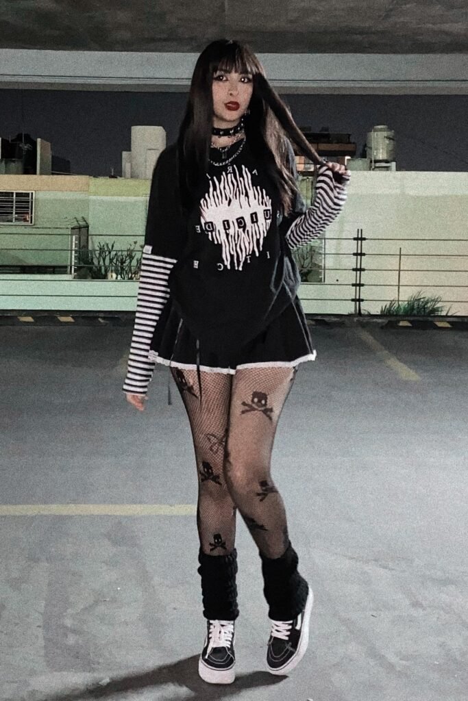 Oversized Graphic T-shirt + Striped Long Sleeve Underlay + Black Skirt + Patterned Fishnets + Leg Warmers + Sneakers