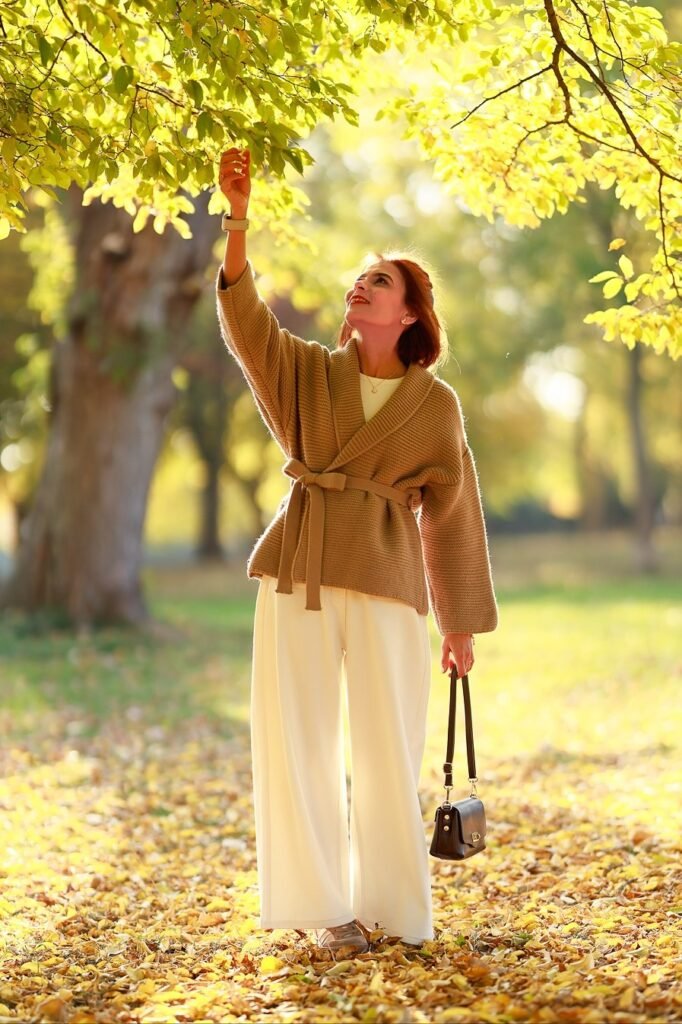 Tan Wrap-Front Cardigan + White Wide-Leg Trousers + Beige Sneakers + Small Black Shoulder Bag