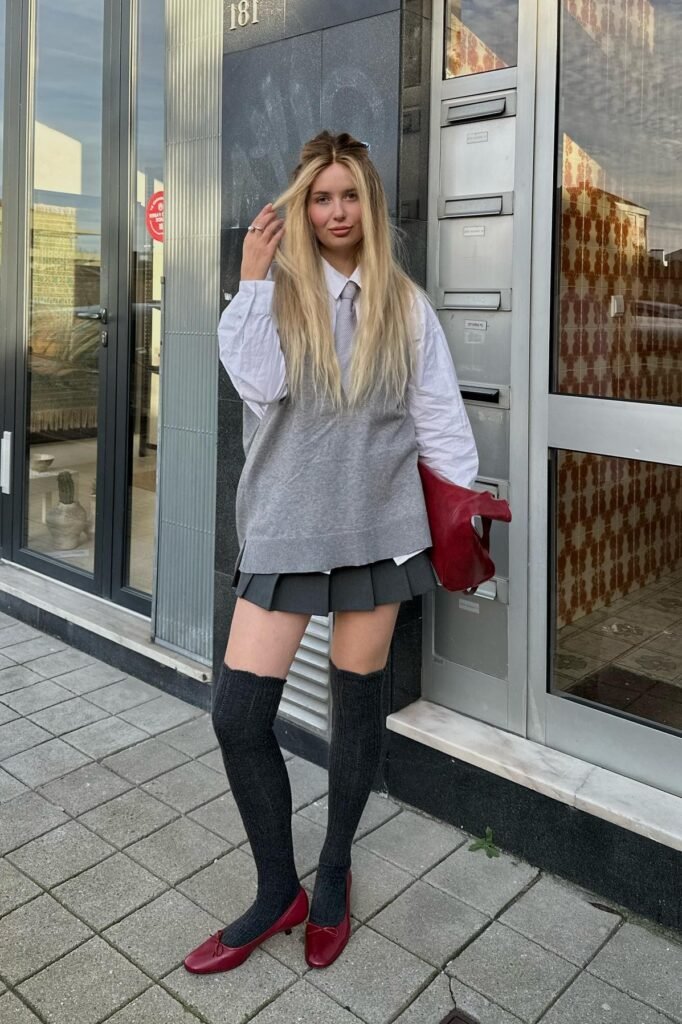 White Button-Up Shirt + Grey Oversized Sweater Vest + Grey Pleated Mini Skirt + Black Over-the-Knee Socks + Red Ballet Flats