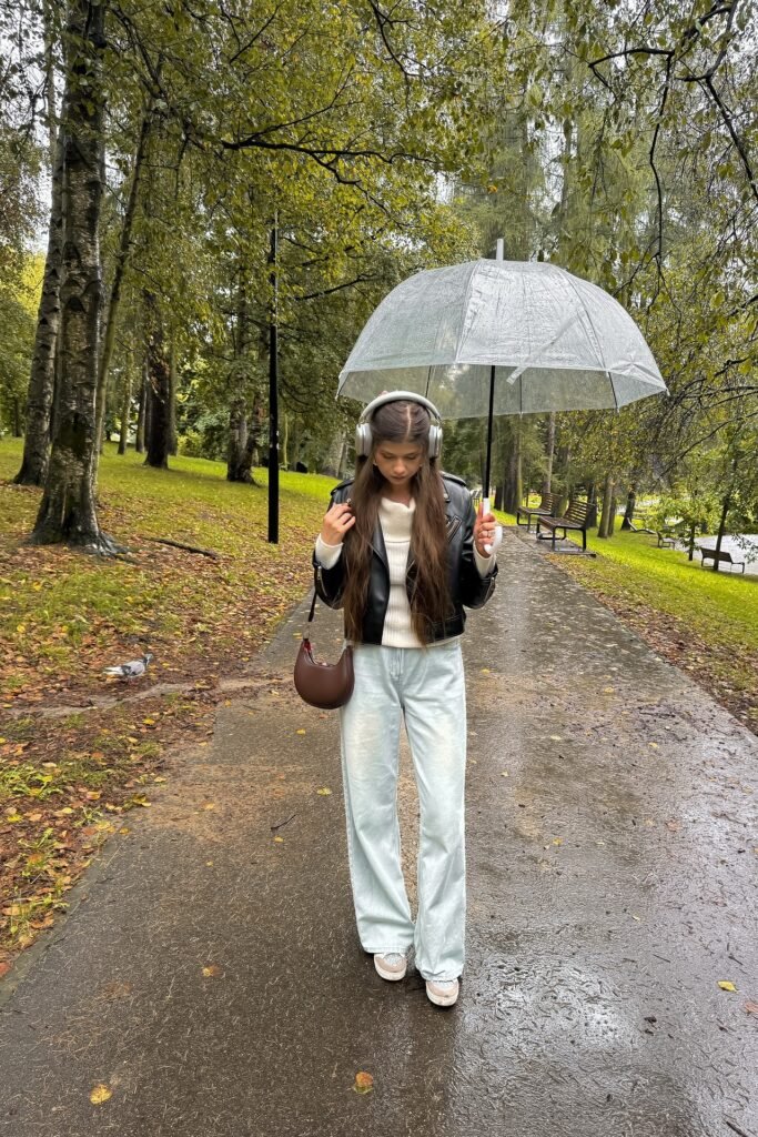 White Cowl-Neck Sweater + Black Leather Biker Jacket + Light-Wash Wide-Leg Jeans + Beige Sneakers