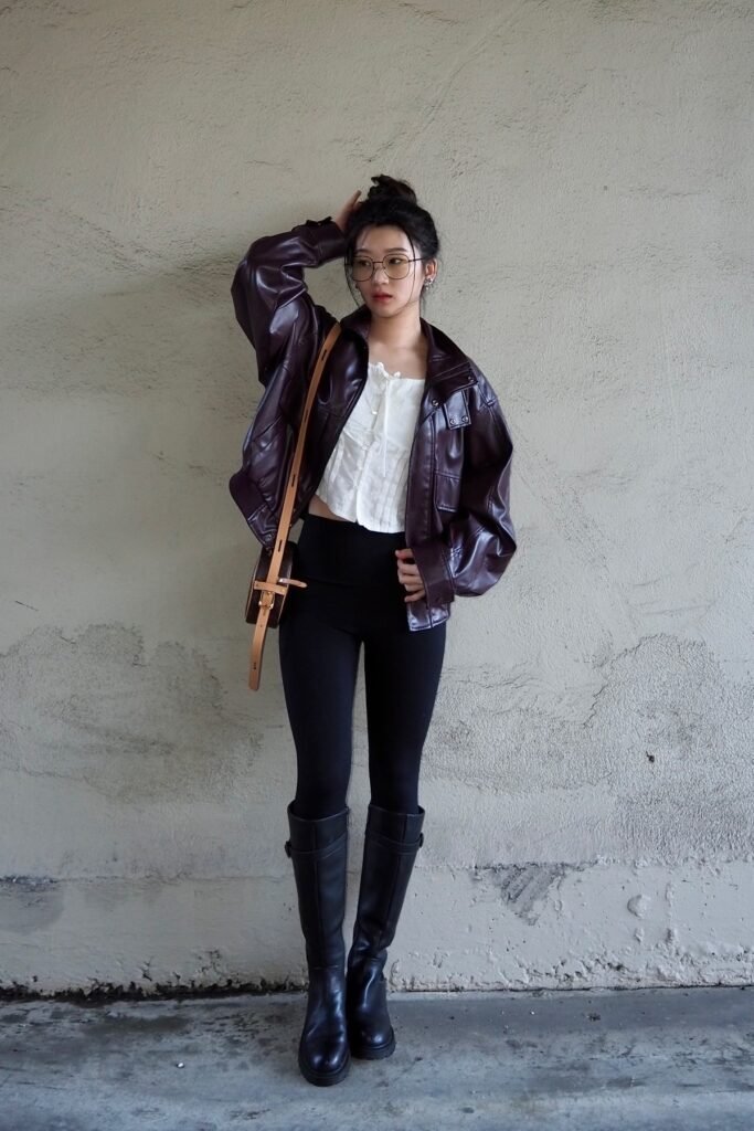 White Eyelet Corset Top + Oversized Burgundy Leather Bomber Jacket + Black Leggings + Tall Black Boots