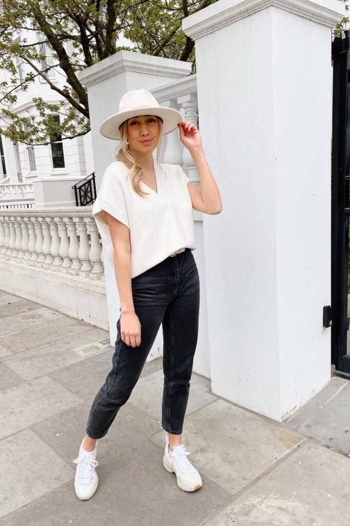 White Fedora + Cream V-Neck Sweater Vest + Black Tapered Jeans + White Sneakers
