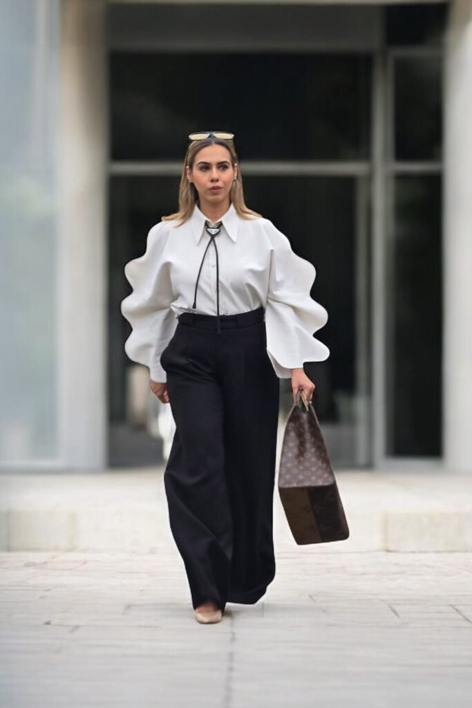 White Ruffle-Sleeve Blouse with Bolo Tie + Black High-Waisted Wide-Leg Trousers + Nude Pointed-Toe Flats