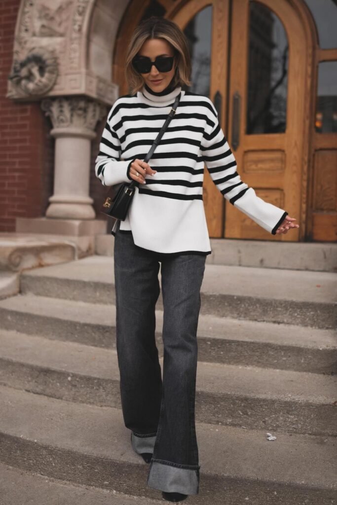 Parisian-inspired chic brunch outfit with a black and white striped turtleneck sweater, charcoal wide-leg cuffed jeans, and pointed boots.